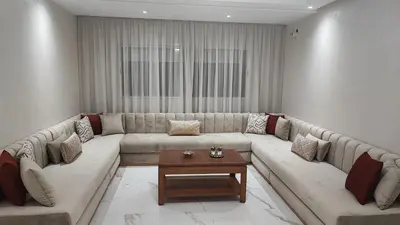 a living room with a large couch and a table at Appartement familial vue piscine in Temara