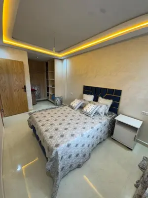 a bedroom with a large bed in a room at Cozy modern apartment 3 min drive beach access in Sidi Rahal
