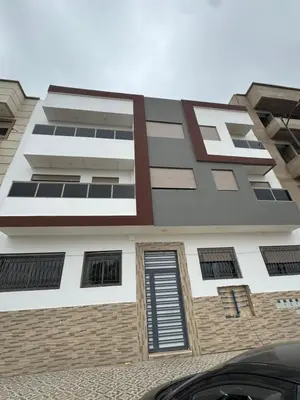a building with many windows on the side of it at Cozy modern apartment 3 min drive beach access in Sidi Rahal