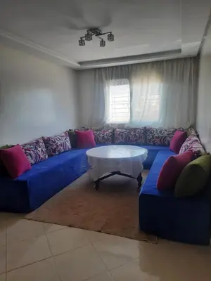 a living room with a blue couch and a coffee table at Séjour Idéal à Tamaris Appartement Meublé Tout Confort in Tamaris