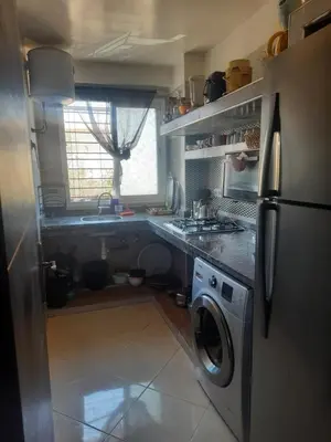 a kitchen with a refrigerator and a washing machine at Séjour Idéal à Tamaris Appartement Meublé Tout Confort in Tamaris