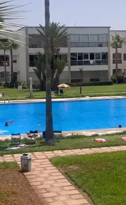 a large swimming pool in front of a building at Résidence balnéaire casablanca in Dar el Maïzi