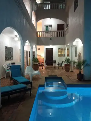 a large swimming pool in a building with a pool at Riad JOUHARA in Skhirat