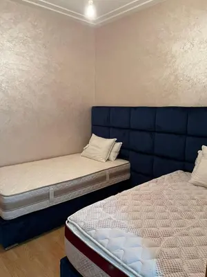 a bedroom with two beds and a blue couch at Détente et confort en face de mer in Casablanca
