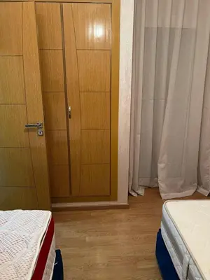 a bedroom with two beds and a wooden door at Détente et confort en face de mer in Casablanca