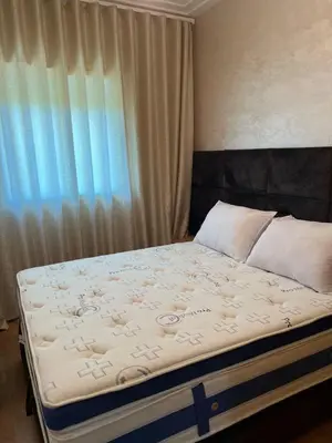 a bed in a room with a window and a bedskirtspectspects at Détente et confort en face de mer in Casablanca