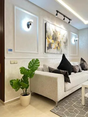 a living room with a couch and a plant at M4 Spacious Appartment in Exclusive Residence by the Sea in Rabat