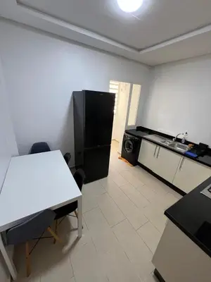 a kitchen with a white table and a black refrigerator at M4 Spacious Appartment in Exclusive Residence by the Sea in Rabat