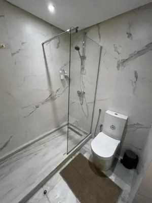 a bathroom with a glass shower and a toilet at M4 Spacious Appartment in Exclusive Residence by the Sea in Rabat