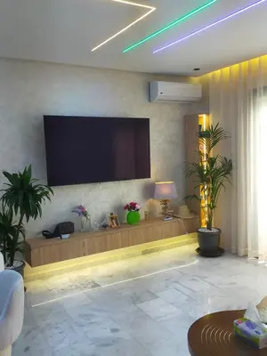 a living room with a flat screen tv on the wall at CASABLANCA BORD dE MER A 200 m DE LA PLAGE Appartement Haut de gamme 2 Chambres avec 2 Salles de bain Piscine Salle de Sport plage in Casablanca