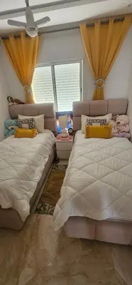 a bedroom with two beds and a window at Appartement vue sur piscine kettani in Bouznika