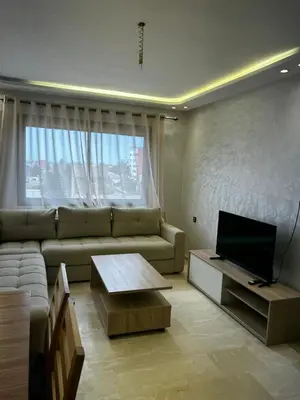 a living room with a couch and a television at Nouvel Appartement Parc Mohammedia in Mohammedia
