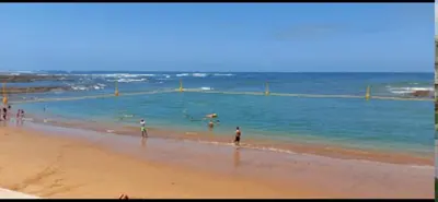 a group of people walking on the beach at Bahía Golf Beach BOUZNIKA in Bouznika