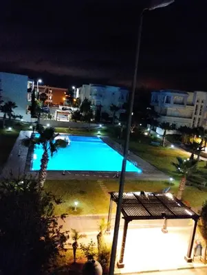 a view of a swimming pool at night at Bahía Golf Beach BOUZNIKA in Bouznika