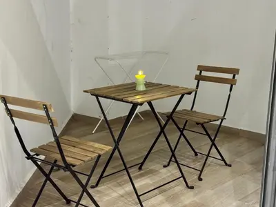 a wooden table with two chairs and a candle on it at Duplex franceville in Casablanca
