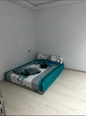 a bedroom with a bed with a blue and white comforter at Superb appartement moyen standing au cœur de Aïn Sebàa in Casablanca