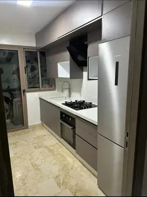 a kitchen with a refrigerator and a stove top oven at Superb appartement moyen standing au cœur de Aïn Sebàa in Casablanca