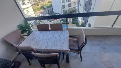 a table and chairs in a room with a large window at Sublime appartement à MANSOURIA in Mansouria