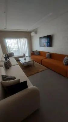 a living room with two couches and a table at Sublime appartement à MANSOURIA in Mansouria