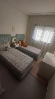 a bedroom with two beds and a teddy bear sitting on top at Sublime appartement à MANSOURIA in Mansouria