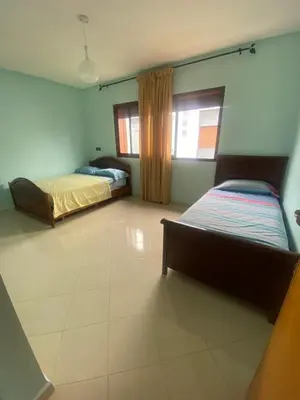 a bedroom with two beds and a window at Villa sécurisée avec piscine à louer in Sidi Rahal