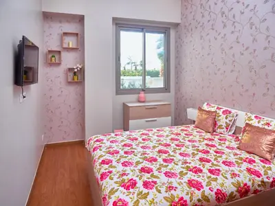 a bedroom with a bed with a floral bedspread at Appartement haut standing in Casablanca