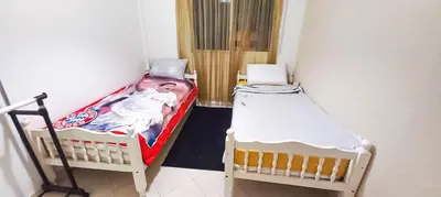 two twin beds in a small room with at Budget-Friendly Apartment Near AirPort in Nouaseur