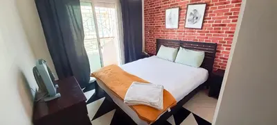 a small bed in a room with a brick wall at Budget-Friendly Apartment Near AirPort in Nouaseur
