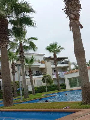 a resort with palm trees and a swimming pool at Berrada in Dar Mohammed Ould Haj Jilali