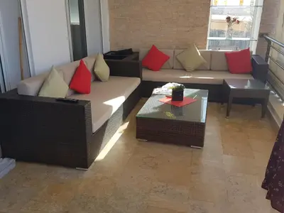 a living room with a couch with red and yellow pillows at Berrada in Dar Mohammed Ould Haj Jilali