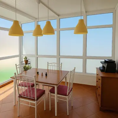 a dining room with a table and chairs and windows at Appartement cosy en plein quartier d'affaires in Casablanca