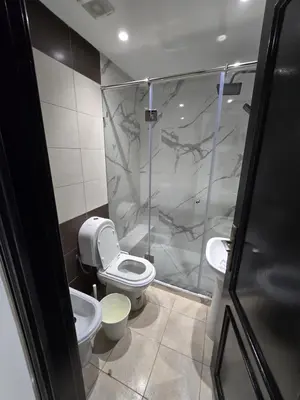 a bathroom with a shower and a toilet and a sink at Appartement cosy en plein quartier d'affaires in Casablanca