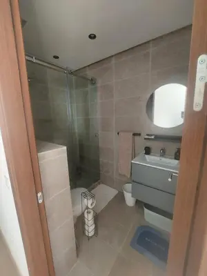 a bathroom with a shower and a toilet and a sink at Duplex de Luxe avec Vue Mer a Zenata City-Eco in Aïn Harrouda