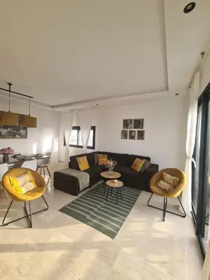 a living room with a couch and a table and chairs at Duplex de Luxe avec Vue Mer a Zenata City-Eco in Aïn Harrouda