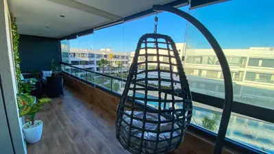 a hammock hanging from a balcony in a building at Résidence luxueuse avec 5 Piscine A MANSOURIA près de la Mer in O Ben Slimane