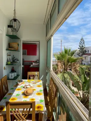 a dining room with a table and a large window at Élégance Océanique in Casablanca