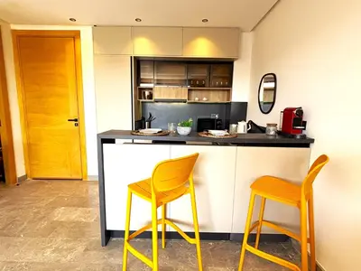 a kitchen with two yellow chairs at a counter at Casa Tina in Casablanca