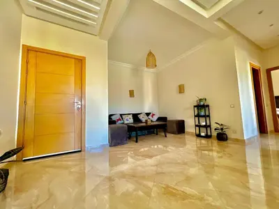 a living room with a couch and a wooden door at Casabay Kettani Sidi Rahal in Sidi Rahal