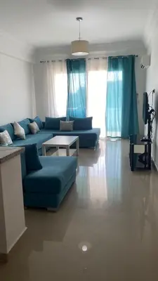 a living room with a blue couch and a table at Unité dans un complexe prestigieux Marina Golf in Settat