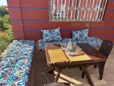 a table and a couch with pillows on a patio at Ferme touristique domaine BENJDYA à HAD SOUALEM in Berrechid