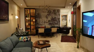 a living room with a couch and a dining room at appart luxueuse a rabat hay riad avec piscine in Rabat