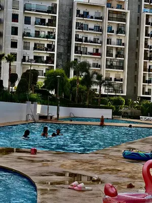 a group of people in a swimming pool with buildings at appart luxueuse a rabat hay riad avec piscine in Rabat