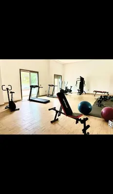 a gym with many exercise equipment in a room at Two bedroom Apartment in Bouznika Beach in Bouznika