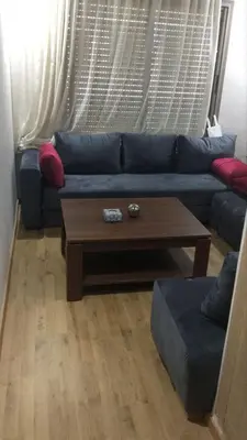 a living room with a blue couch and a coffee table at Two bedroom Apartment in Bouznika Beach in Bouznika
