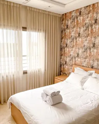 a bedroom with a white bed with towels on it at Stylish 1BR in Racine - Prime Racine Location in Casablanca