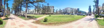 a park with trees and cars on a city street at Confort & Style à Mohammedia parc in Mohammedia
