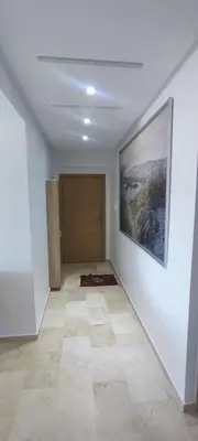 a hallway with a painting on the wall and a door at Confort & Style à Mohammedia parc in Mohammedia