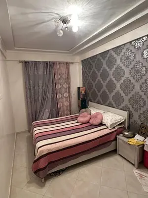 a bedroom with a bed with pink pillows on it at Appartement sidi rehal in Casablanca