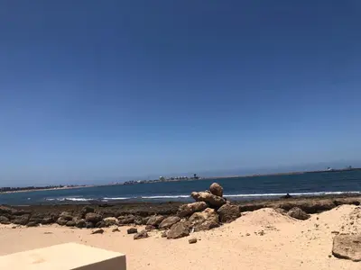 a pile of rocks on a beach with the ocean at Chambre cosy en bord de mer in Mohammedia