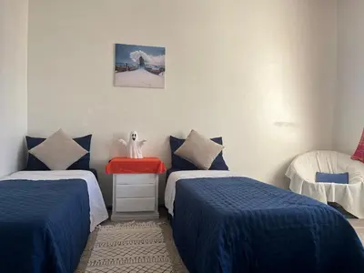 a room with two beds and a red table at Chambre cosy en bord de mer in Mohammedia